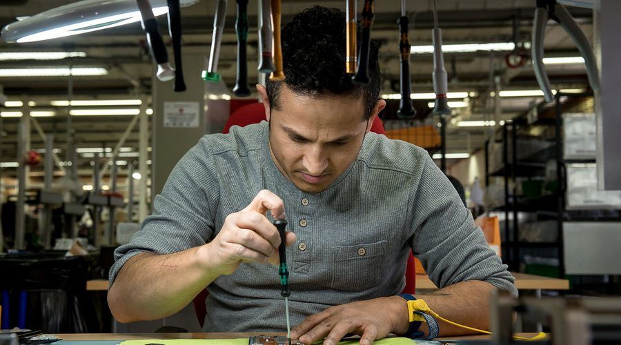 Un technicien des Ateliers du Bocage répare un appareil à l'établi