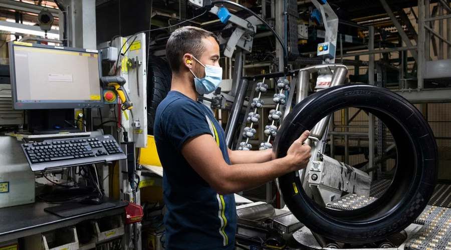 Un opérateur contrôle un pneu dans un atelier de rechapage