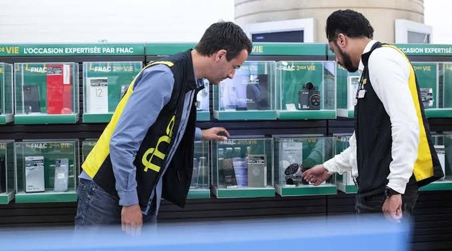 Deux vendeurs devant le rayon d'occasion expertisée de la Fnac